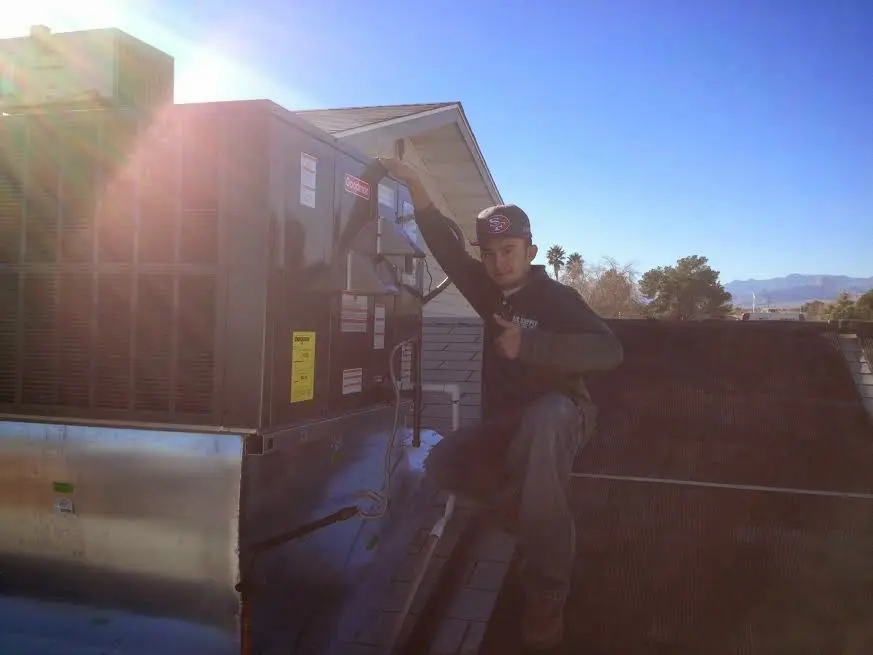 HVAC technician performing AC Tune-Up on a rooftop unit in Lake Monticello