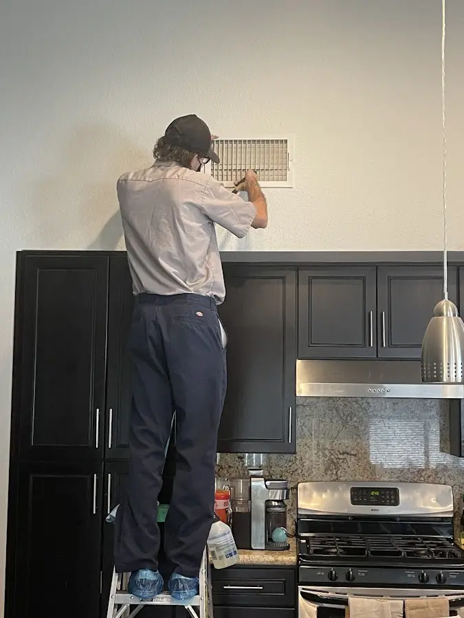 Technician inspecting an air vent during HVAC service in Lake Monticello